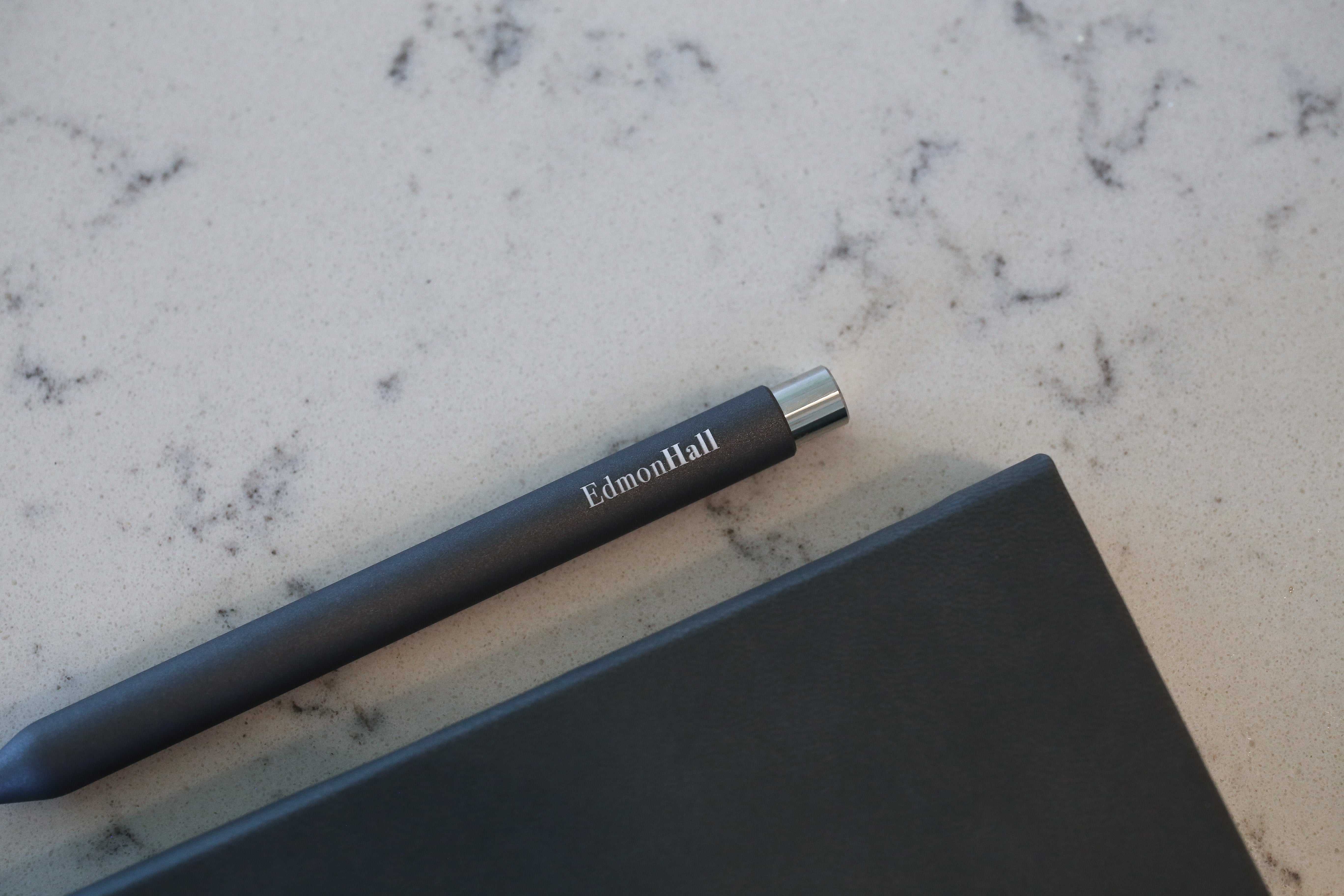 An engraved pen next to a notebook